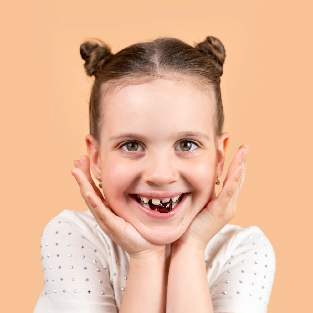 Dievčatko s multivitamínom v zuboch